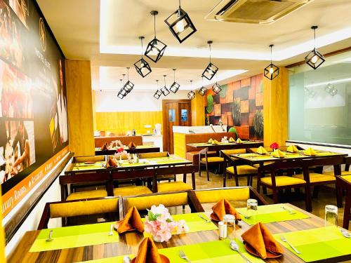 a restaurant with tables and yellow chairs and a dining room at Hotel Park Airport Zone Hyderabad in Shamshabad