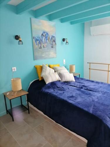 - une chambre bleue avec un grand lit et une table dans l'établissement chez frédérique, à Saint-Trojan-les-Bains