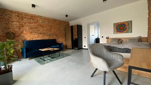 a bedroom with a blue couch and a brick wall at Apartamenty Gliwice Staromiejska 65 in Gliwice