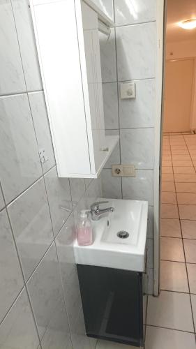 uma casa de banho com um lavatório branco e um espelho. em 2-Zimmerwohnung em Berlim