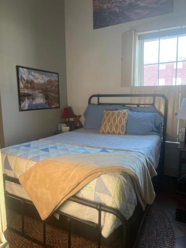 1 dormitorio con cama con sábanas azules y ventana en First Floor Apt with River View en Hallowell