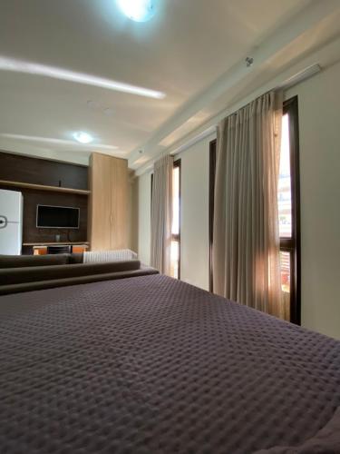 a large bed in a room with a large window at Apartamento no Park Sul - Brasília in Brasilia