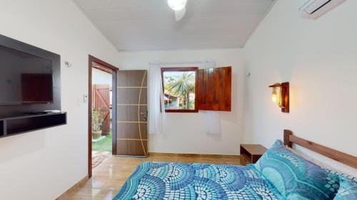 sypialnia z łóżkiem i telewizorem w pokoju w obiekcie Espaço HaRo w mieście São Miguel do Gostoso