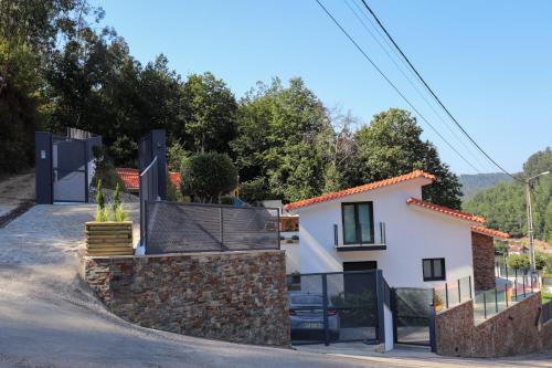 uma casa com um portão e uma parede de pedra em Bela Vista Urtigosa em Arouca