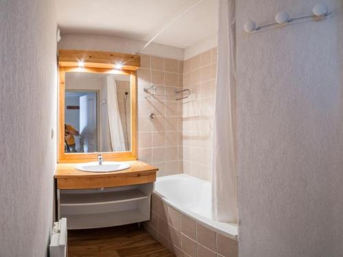 a bathroom with a sink and a tub and a mirror at Appartement à la Montagne The view in Albiez-Montrond