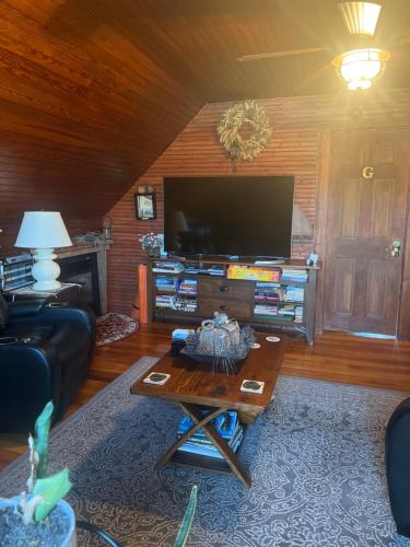 ein Wohnzimmer mit einem TV und einem Couchtisch in der Unterkunft Hallowell Rooming House in Hallowell