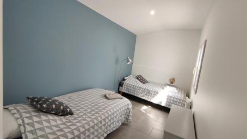2 Betten in einem kleinen Zimmer mit blauen Wänden in der Unterkunft Impression du Sud Gîte 2 in Saint-Rémy-de-Provence
