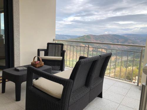 a balcony with chairs and a table with a view at Casa da Forja in Aldeia das Dez