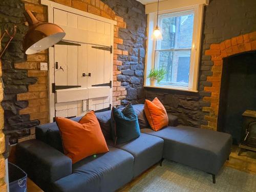 een woonkamer met een blauwe bank en kleurrijke kussens bij Kennet House in Ludlow