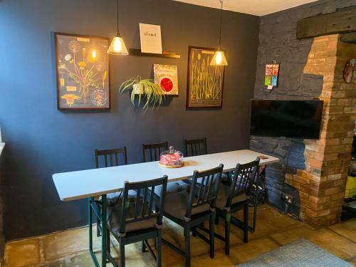 uma sala de jantar com mesa e cadeiras e uma televisão em Kennet House em Ludlow