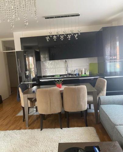 uma sala de estar com mesa e cadeiras e uma cozinha em Gabi apartman em Vranje