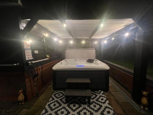 ein Bad mit einer Badewanne in einem lichtdurchfluteten Zimmer in der Unterkunft Luxury 5* Woodland Retreat, In The Woods. in Skegness