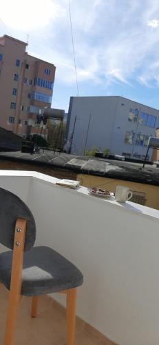 a chair sitting on the ledge of a building at Comfy apartment- Sunny balcony in Tirana