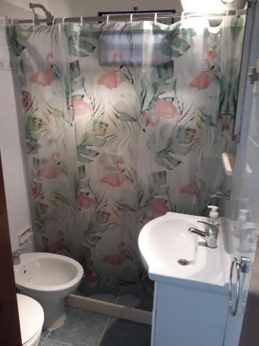 y baño con cortina de ducha, aseo y lavamanos. en Suíte, en Punta del Este