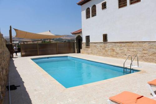 a swimming pool in front of a building at Rosa Farm, Jerash Most Beautiful Villa in Jerash