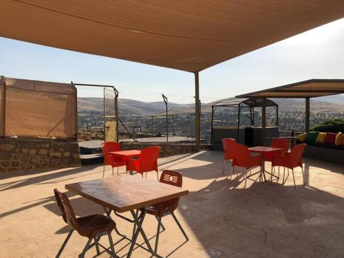a patio with a table and chairs and a view at Rosa Farm, Jerash Most Beautiful Villa in Jerash