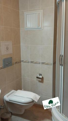 a bathroom with a toilet and a shower stall at Uyku Vadisi Hotel in Ağaçlıhüyük