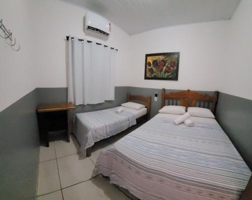 1 Schlafzimmer mit 2 Betten und Klimaanlage in der Unterkunft Casa Flor do Ipê Homes in Nobres