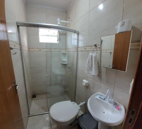 ein Bad mit einer Dusche, einem WC und einem Waschbecken in der Unterkunft Casa Flor do Ipê Homes in Nobres