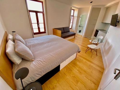 a bedroom with a large bed and a living room at Porto.Leça - Studios and Apts (Apt H) in Leça da Palmeira
