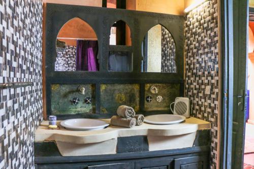 a bathroom with two sinks and a large mirror at Riad Kasbah Omar in Ourika
