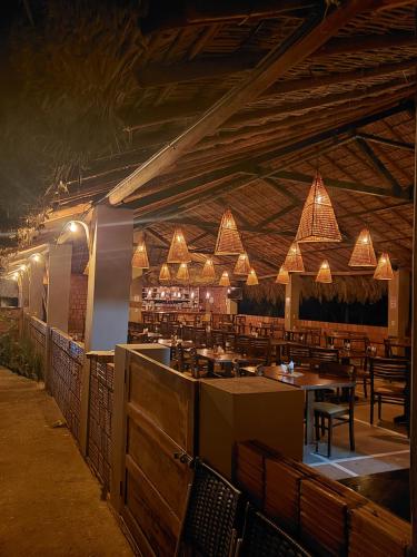 een restaurant met tafels, stoelen en verlichting bij Pousada Beira da Mata-Jalapão in Mateiros