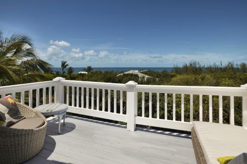 a white railing on a deck with a view of the ocean at Miranda House home in Governorʼs Harbour
