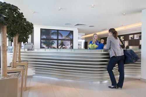 a woman standing at a bar in a store at Aspria Hannover Maschsee Sport & Spa in Hannover