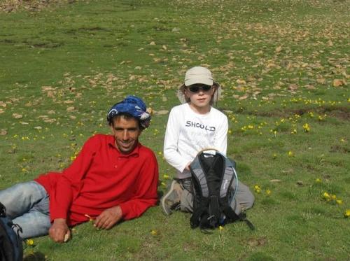 a man and a girl sitting on the grass at Chez L'habitant Brahim kanih in Anzel