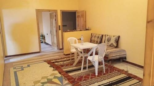 a living room with a table and a couch at Chez L'habitant Brahim kanih 