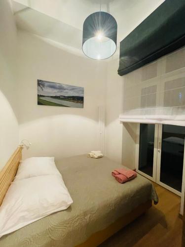 a bedroom with a bed and a lamp and a window at TALIA Apartament Tatarska 4 in Przemyśl
