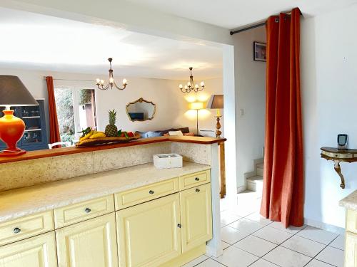 a kitchen with yellow cabinets and a mirror at MAISON DES VIGNES in Embrun