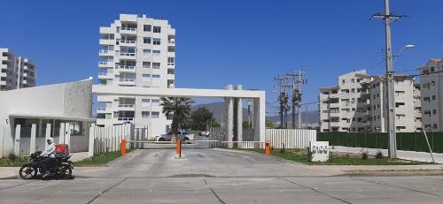 a motorcycle parked in a parking lot with buildings at Bonito y Acogedor Dpto Av Pacífico 3100, La Serena in La Serena