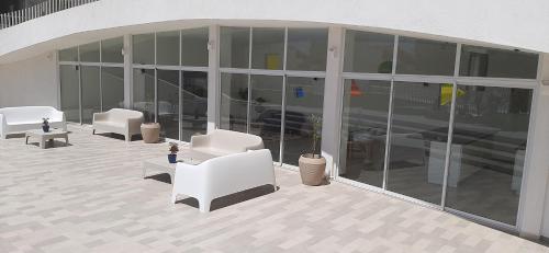 a building with white chairs and tables and windows at Bonito y Acogedor Dpto Av Pacífico 3100, La Serena in La Serena