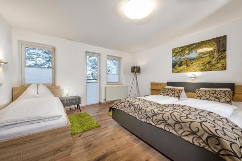 a bedroom with two beds and a painting on the wall at GRUBERS, Hotel Appartments Gastein in Bad Gastein