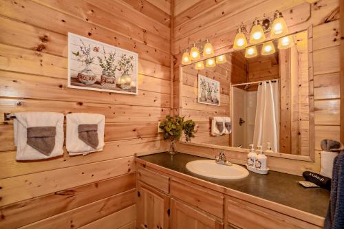 a bathroom with a sink and a mirror at *Family friendly cabin near Dollywood! in Pigeon Forge