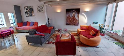 ein Wohnzimmer mit Sofas, Stühlen und einem Tisch in der Unterkunft Le Loft De La Robine 110m2 in Narbonne