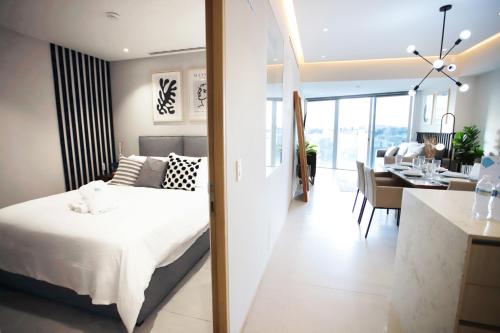 Cet appartement comprend une chambre avec un lit king-size et une cuisine. dans l'établissement LUXETOWN - A luxury experience with pool and gym, à Guadalajara