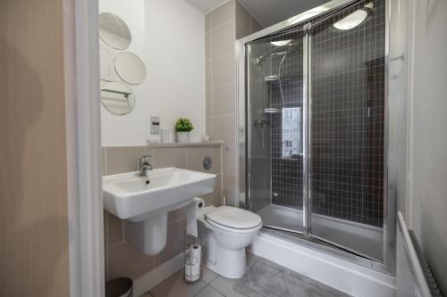 een badkamer met een toilet, een wastafel en een douche bij Modern 2 bed in central MK, Free Parking, Smart TV Dakota By Valore Property Services in Milton Keynes