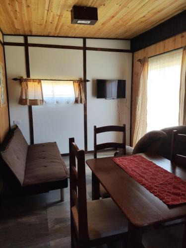a living room with a table and a dining room at RdA Cabaña in Pichilemu