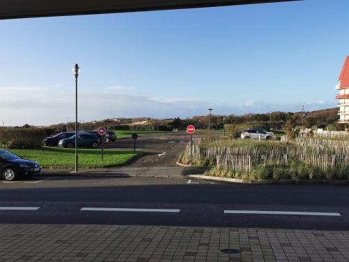 a parking lot with a stop sign and cars parked at Le Pouget , Studio, Rez de Chaussée, Front de Mer WIFI in Le Touquet-Paris-Plage
