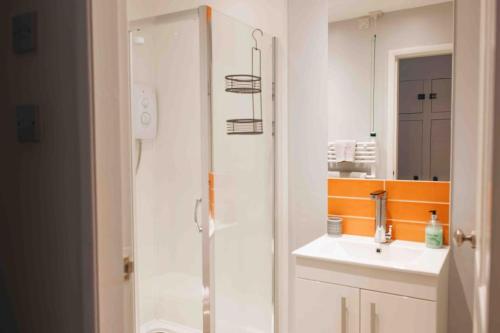 bagno con doccia, lavandino e specchio di Clee Ness - 1 bed maisonette, on the seafront a Cleethorpes