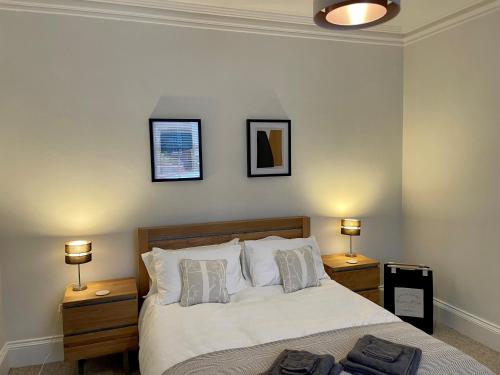 a bedroom with a bed with two night stands and two lamps at Traditional Cottage in West Kilbride Village in Seamill