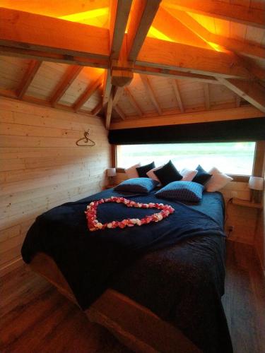ein Schlafzimmer mit einem großen Bett in einer Holzhütte in der Unterkunft La cabane au bain perché 