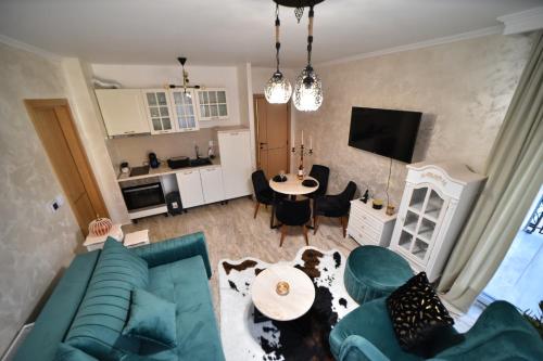 a living room with a blue couch and a table at Apartman Vasilisa in Zlatibor