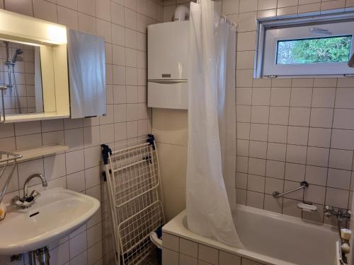 a bathroom with a sink and a tub and a sink at Vakantiehuis Ome Wim op 't Hoogelandt in De Koog
