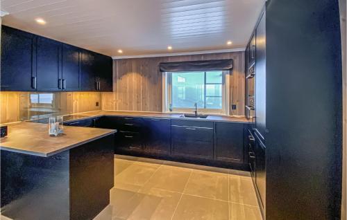 a kitchen with black cabinets and a sink at Nice Home In yer With Kitchen in Øyer