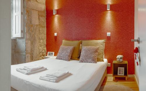 een slaapkamer met een wit bed en een rode muur bij Oporto Pool Apartment by Vacationy in Porto