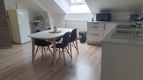 een keuken met een tafel en stoelen in een kamer bij Le Gîte du Val de Noye in Ailly-sur-Noye