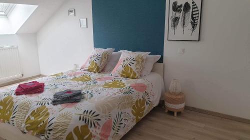 een slaapkamer met een bed met een kleurrijk dekbed bij Le Gîte du Val de Noye in Ailly-sur-Noye